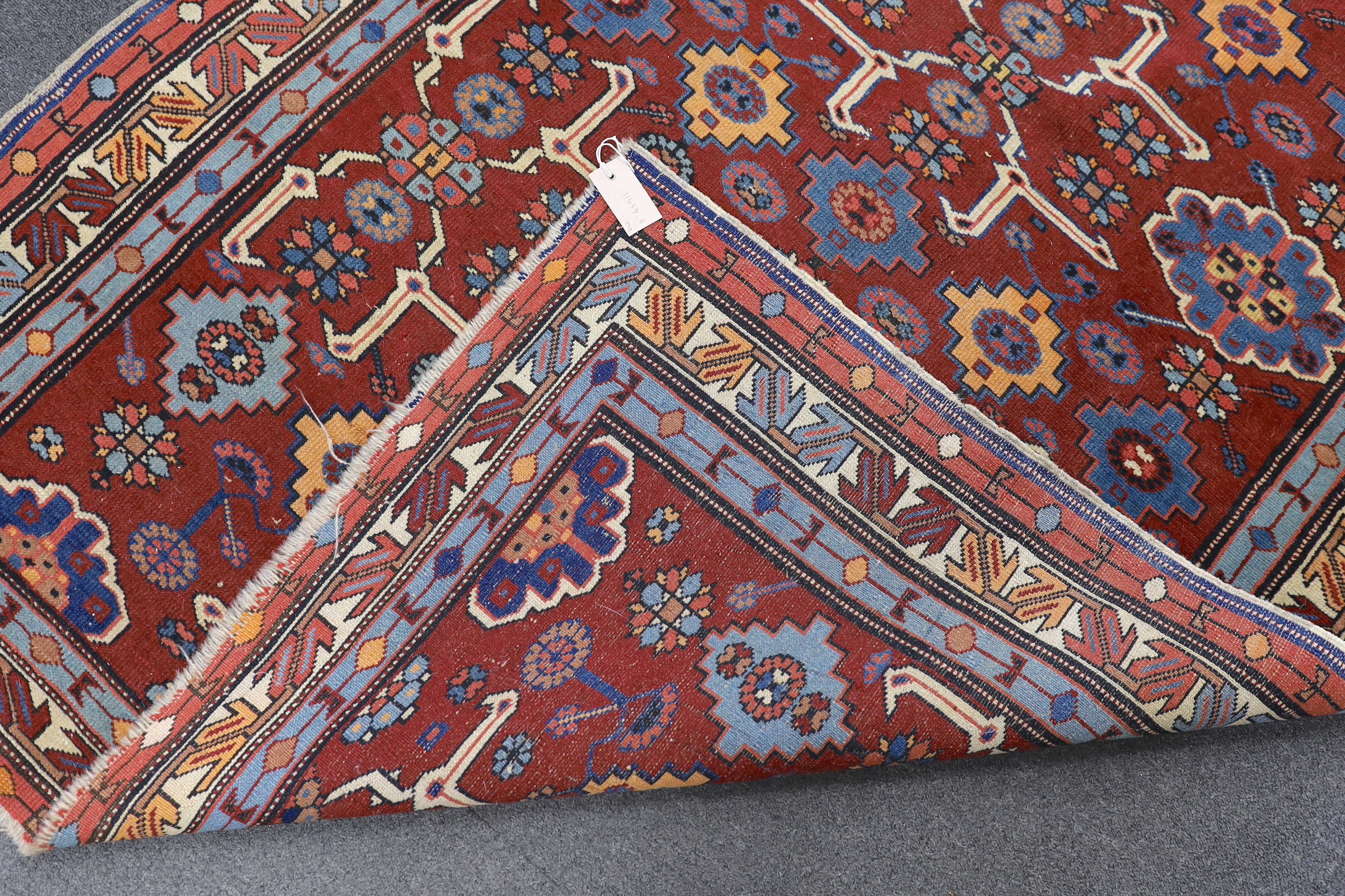 A Caucasian burgundy ground rug, 220 x 128cm